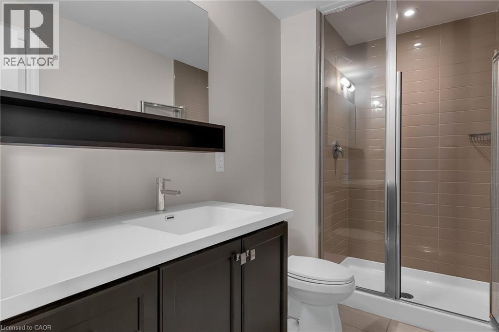 Bathroom featuring a modern vanity with a white countertop, dark wood-finish cabinetry, and an integrated sink - 2 Waterview Lane, Grimsby, ON - Indoor Photo Showing Bathroom