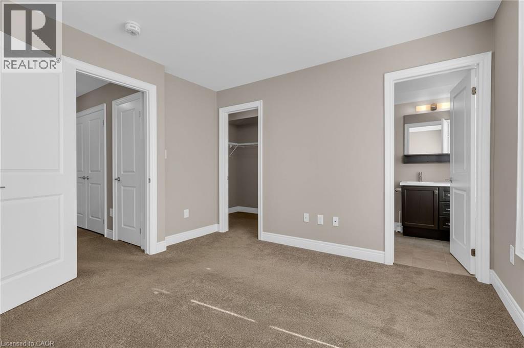 Neutral-toned bedroom featuring plush carpeting, white trim, and a built-in closet with shelving - 2 Waterview Lane, Grimsby, ON - Indoor Photo Showing Other Room