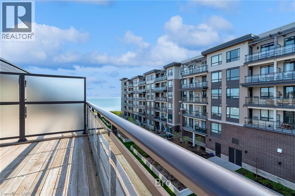 Expansive outdoor balcony featuring wood-finish decking and a glass panel railing - 2 Waterview Lane, Grimsby, ON - Outdoor With Balcony