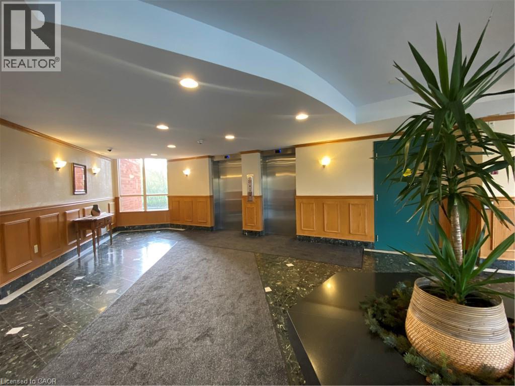 Lobby area featuring rich paneled wainscoting, polished stone flooring, recessed lighting, and wall sconces - 30 Blue Springs Drive Unit# Ph3, Waterloo, ON - Indoor Photo Showing Other Room