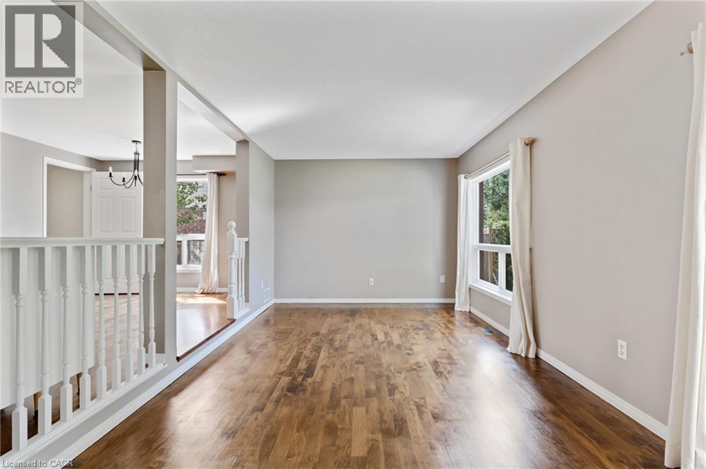 Spacious room featuring wood-finish flooring, neutral wall tones, and white trim - 129 Kovac Road, Cambridge, ON - Indoor Photo Showing Other Room