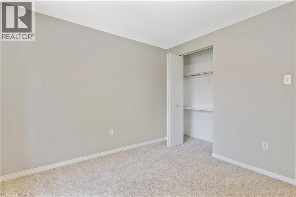 Neutral-toned carpeted room featuring a built-in closet with shelving and hanging rod - 129 Kovac Road, Cambridge, ON - Indoor Photo Showing Other Room