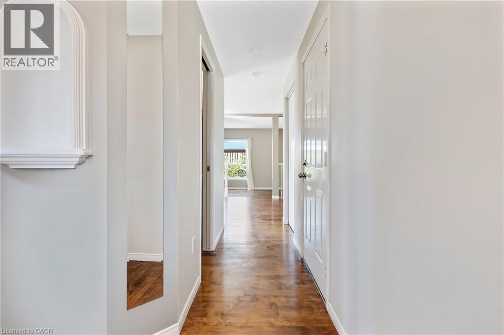 Hallway featuring wood-finish flooring, light grey painted walls, recessed lighting, and a decorative wall niche with a shelf - 129 Kovac Road, Cambridge, ON - Indoor Photo Showing Other Room