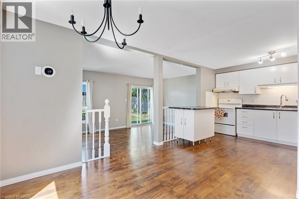 Kitchen featuring white cabinetry, contrasting dark countertops, and white appliances - 129 Kovac Road, Cambridge, ON - Indoor Photo Showing Kitchen