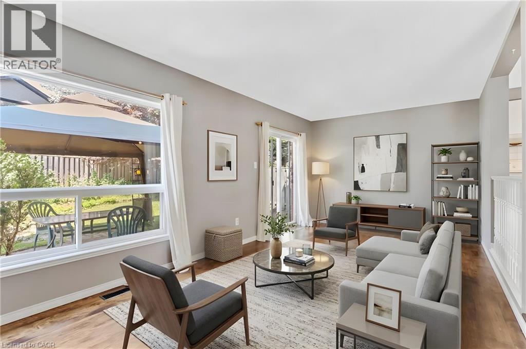 Bright living space featuring wood-finish flooring, light grey walls, and a large picture window - 129 Kovac Road, Cambridge, ON - Indoor Photo Showing Living Room