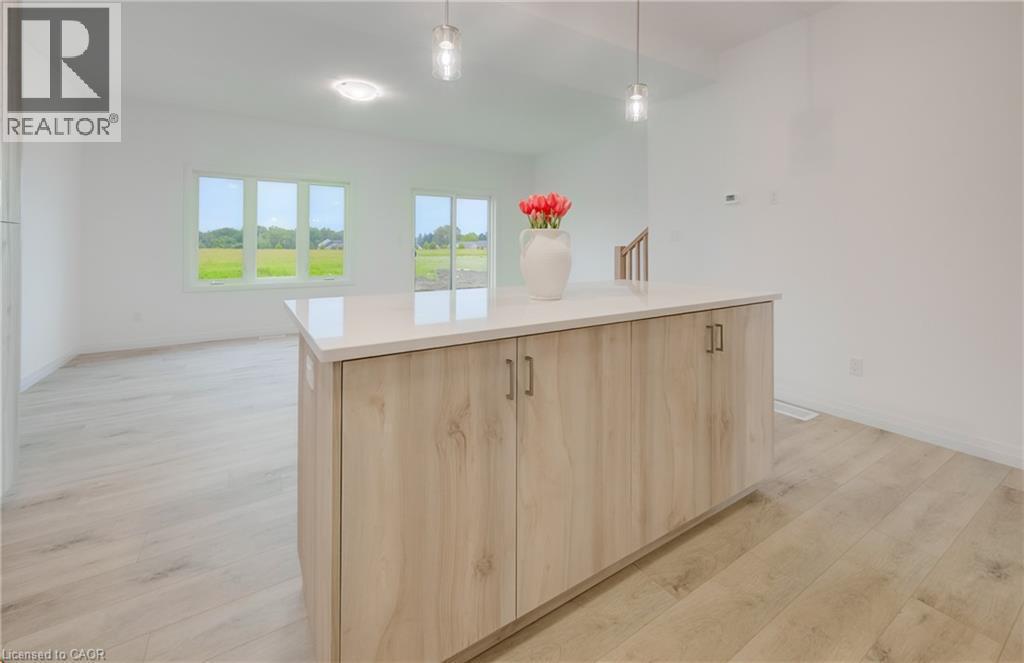 Kitchen island featuring wood-finish cabinetry and a light-toned countertop - 89 Rivergreen Crescent, Cambridge, ON - Indoor
