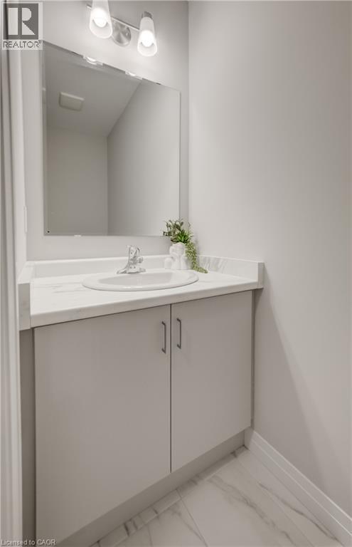 Bathroom vanity featuring a built-in sink, light-toned countertop, and dual-door cabinetry - 89 Rivergreen Crescent, Cambridge, ON - Indoor Photo Showing Bathroom