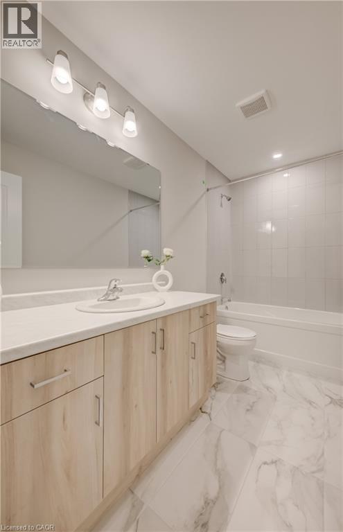 Bathroom featuring a light wood-finish vanity with an integrated sink, a white countertop, and a large mirror - 89 Rivergreen Crescent, Cambridge, ON - Indoor Photo Showing Bathroom