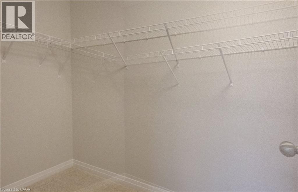 Walk-in closet featuring wire shelving, wire hanging rods, neutral wall paint, and carpeting - 89 Rivergreen Crescent, Cambridge, ON - Indoor With Storage