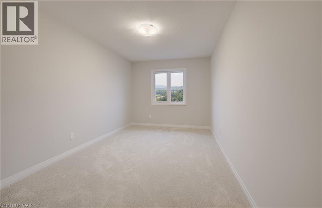 Bright room featuring neutral-toned carpeting and walls, a white trim package, and a window providing natural illumination - 89 Rivergreen Crescent, Cambridge, ON - Indoor Photo Showing Other Room