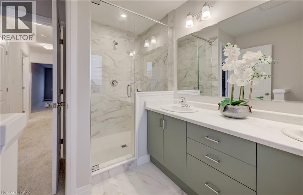 Spacious bathroom featuring a glass-enclosed shower with marble-look tile, a dual-sink vanity with light green cabinetry, and chrome fixtures - 89 Rivergreen Crescent, Cambridge, ON - Indoor Photo Showing Bathroom