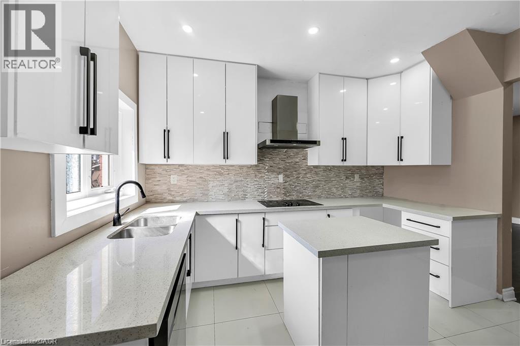 Contemporary kitchen featuring white cabinetry with black hardware, quartz countertops, and a tile-finish flooring - 334 Cannon Street E, Hamilton, ON - Indoor Photo Showing Kitchen With Upgraded Kitchen
