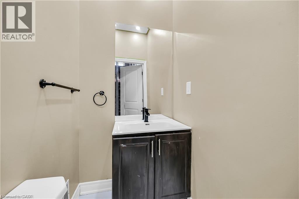 Vanity with dark wood-finish cabinetry, white countertop, and integrated sink - 334 Cannon Street E, Hamilton, ON - Indoor Photo Showing Bathroom