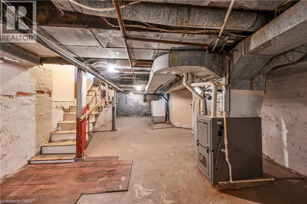 Utility space featuring exposed brick foundation, concrete flooring, and visible overhead ductwork - 334 Cannon Street E, Hamilton, ON - Indoor Photo Showing Basement