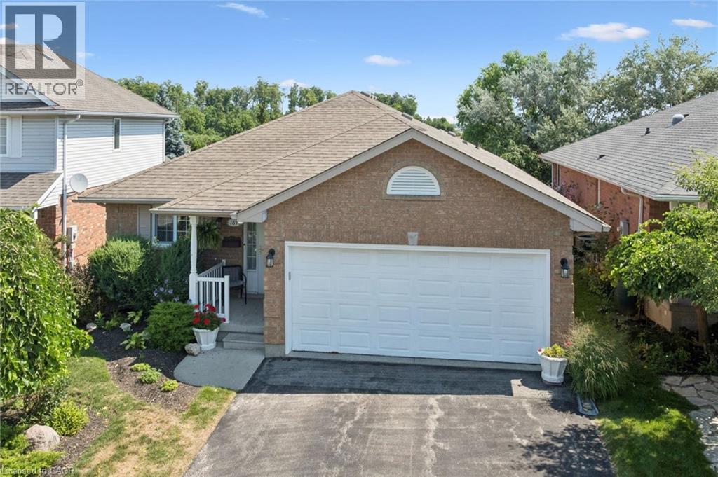 All brick exterior featuring a two-car garage, covered porch entry, and established landscaping - 187 Westchester Drive, Kitchener, ON - Outdoor