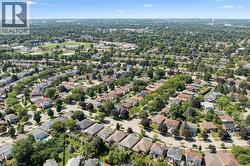 Expansive residential area featuring numerous detached homes with diverse architectural styles, abundant mature trees, and paved streets -