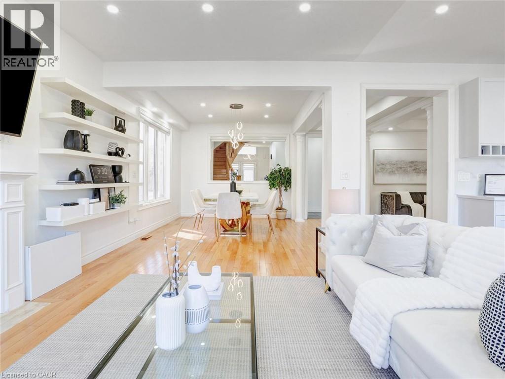 Open-concept living space with light wood-finish flooring, recessed lighting, and a white fireplace mantel - 584 Pinery Trail, Waterloo, ON - Indoor Photo Showing Living Room