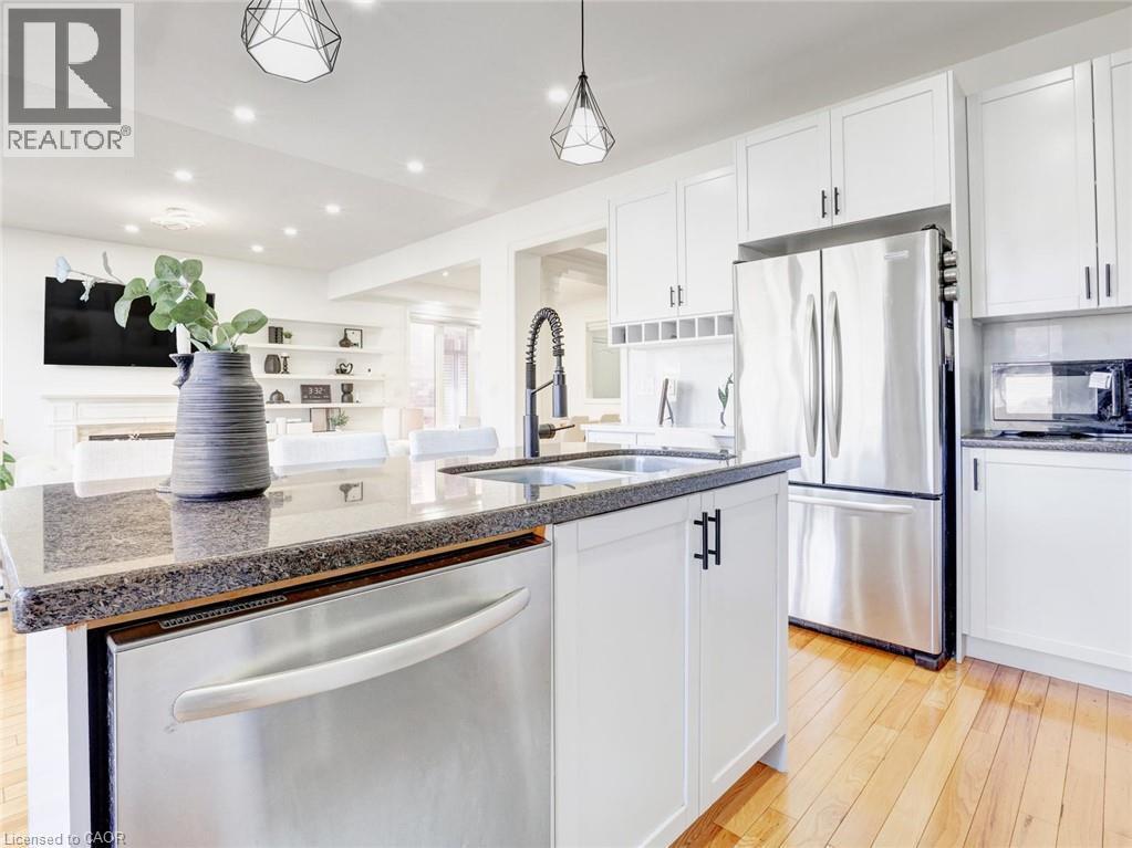 Kitchen island featuring a dark speckled countertop, undermount sink, and stainless steel dishwasher - 584 Pinery Trail, Waterloo, ON - Indoor Photo Showing Kitchen With Double Sink With Upgraded Kitchen