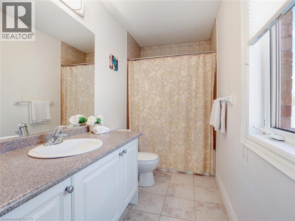 Full bathroom featuring a single vanity with a laminate countertop, white cabinetry, and an oval undermount sink - 584 Pinery Trail, Waterloo, ON - Indoor Photo Showing Bathroom