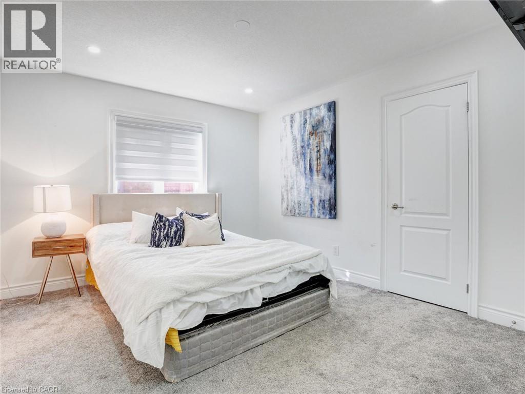 Plush gray carpeting throughout, featuring white painted walls, a window with horizontal blinds, recessed lighting, and a white interior door - 584 Pinery Trail, Waterloo, ON - Indoor Photo Showing Bedroom