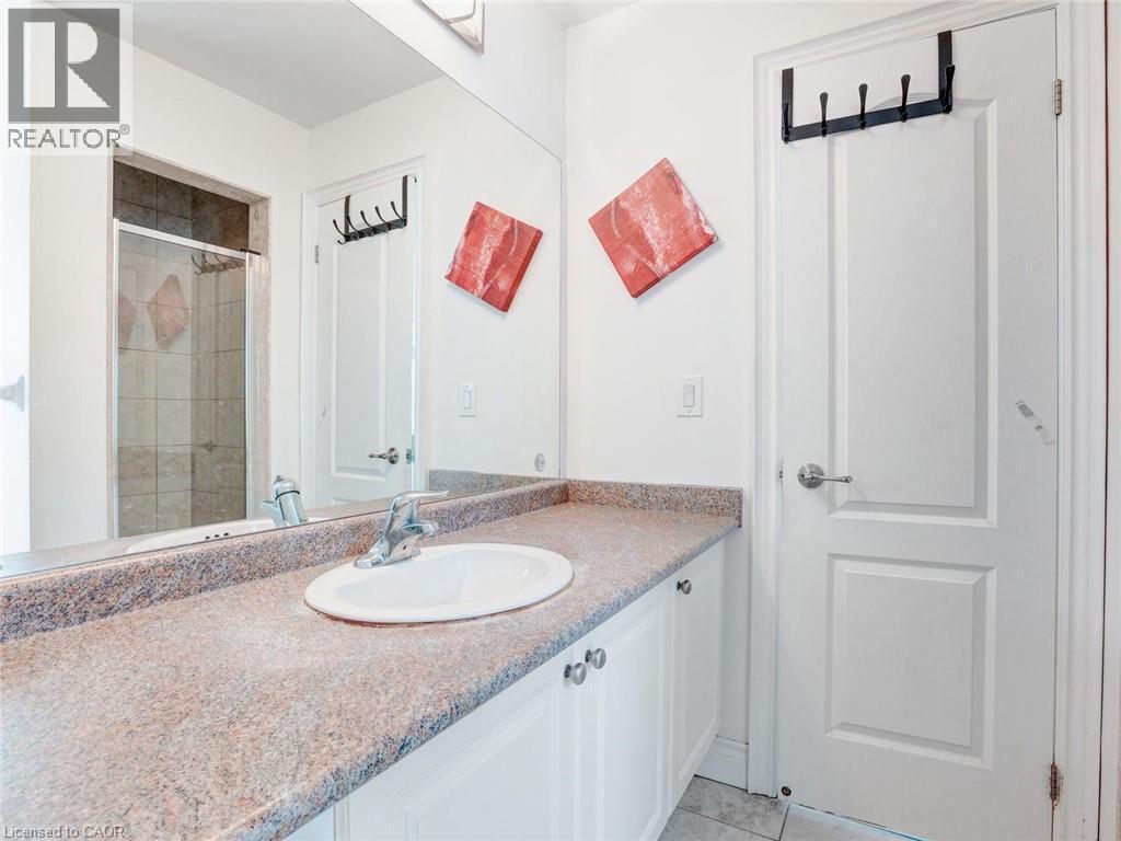 Bathroom vanity featuring a built-in sink, chrome faucet, and speckled countertop - 584 Pinery Trail, Waterloo, ON - Indoor Photo Showing Bathroom