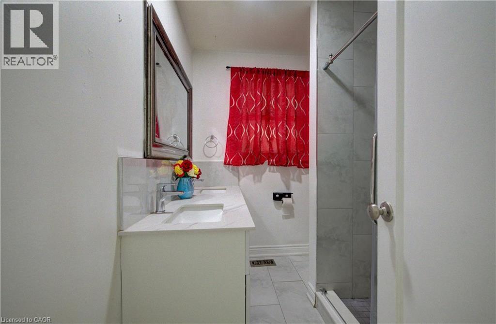 Bathroom vanity featuring a rectangular undermount sink, a chrome-finish faucet, and a stone-look countertop - 182 Avalon Place, Kitchener, ON - Indoor Photo Showing Bathroom