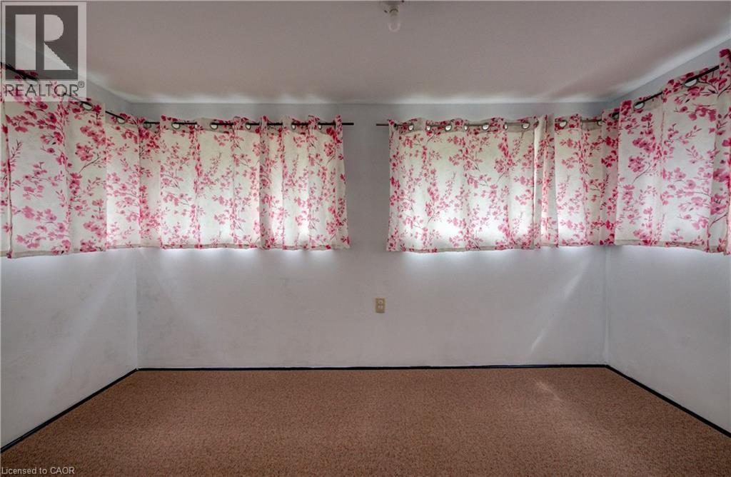 Light-colored walls featuring multiple windows, carpet flooring, and a ceiling-mounted light fixture - 182 Avalon Place, Kitchener, ON - Indoor Photo Showing Other Room