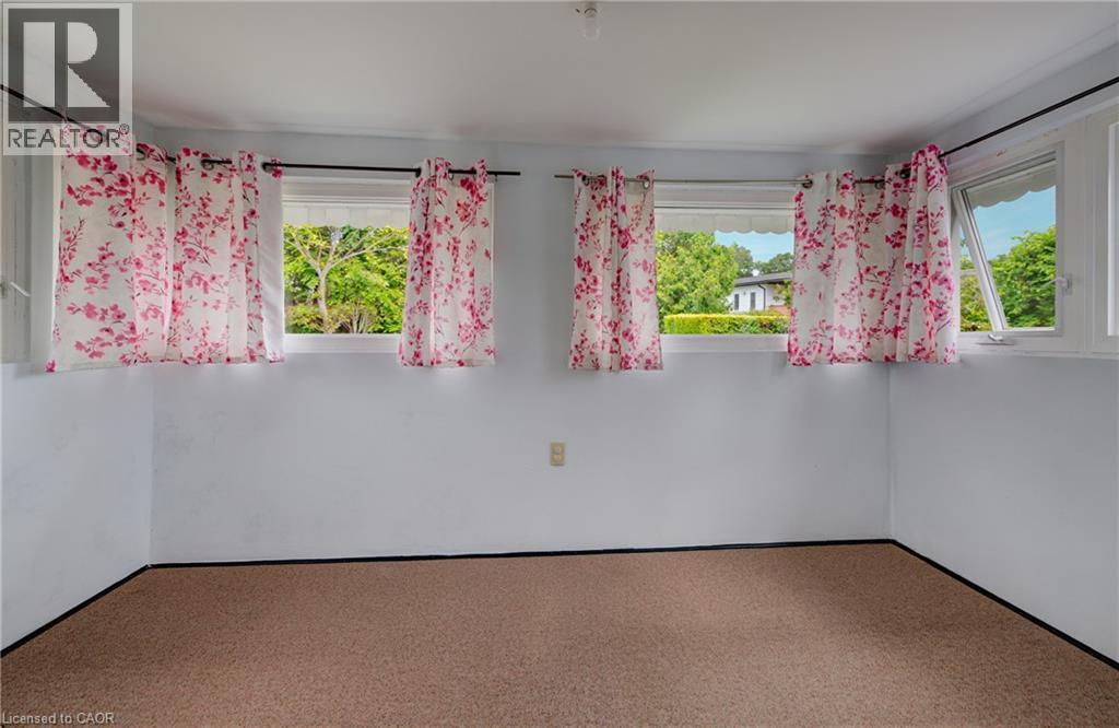 Bright room featuring multiple windows, white painted walls, and light-colored carpet flooring - 182 Avalon Place, Kitchener, ON - Indoor Photo Showing Other Room