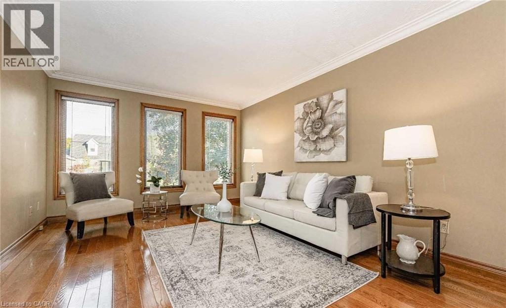 Hardwood flooring, crown molding, three windows, neutral wall tones, and recessed lighting - 28 Walnut Drive, Guelph, ON - Indoor Photo Showing Living Room