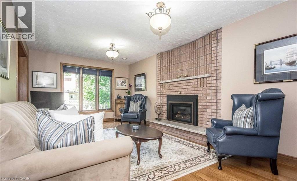 Brick-clad fireplace with a stone hearth and mantel - 28 Walnut Drive, Guelph, ON - Indoor Photo Showing Living Room With Fireplace