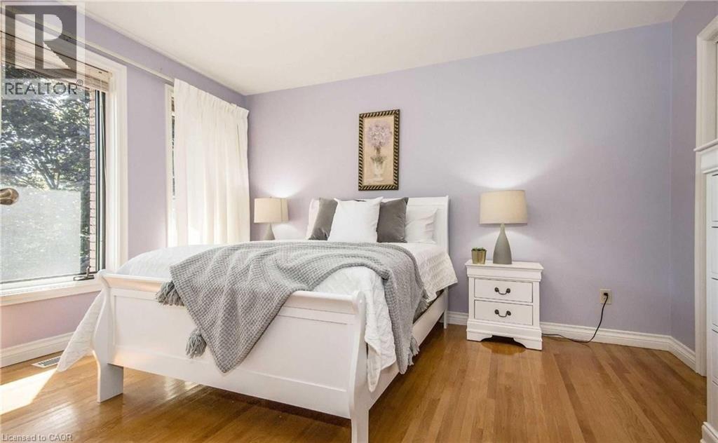 Hardwood flooring, light purple wall color, white trim, and a window with a white frame - 28 Walnut Drive, Guelph, ON - Indoor Photo Showing Bedroom