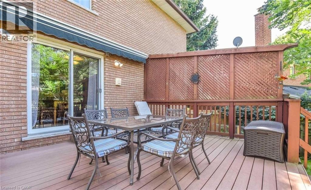 Spacious outdoor deck featuring wood-finish flooring, lattice fencing, and a sliding glass door - 28 Walnut Drive, Guelph, ON - Outdoor With Deck Patio Veranda With Exterior
