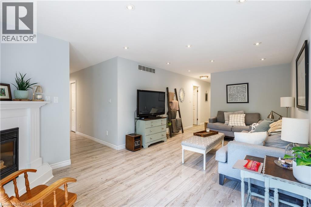 Spacious interior featuring light wood-finish flooring, recessed lighting, and a white fireplace mantel - 907 Doon Village Road, Kitchener, ON - Indoor Photo Showing Living Room With Fireplace