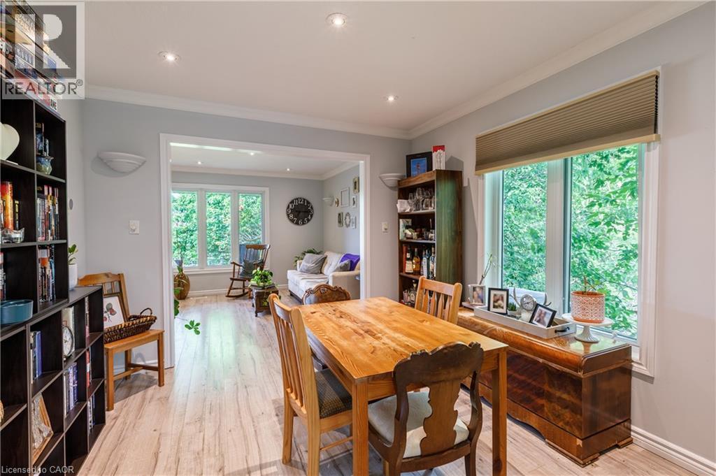 Open-concept dining area featuring wood-finish flooring, recessed lighting, and a large window with privacy blinds - 907 Doon Village Road, Kitchener, ON - Indoor Photo Showing Dining Room