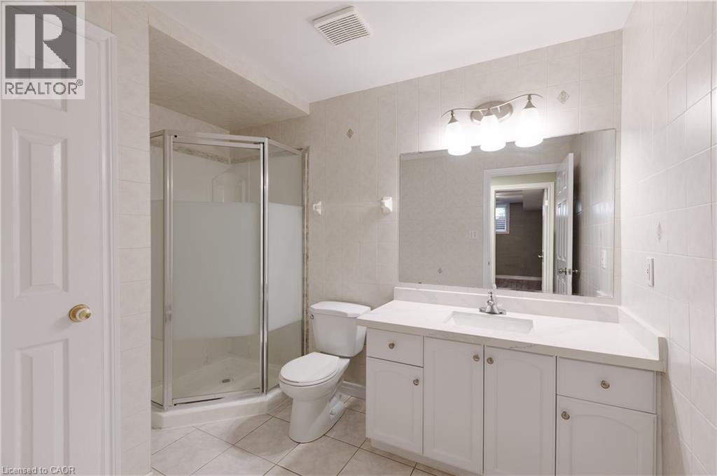 Spa-inspired primary bathroom featuring a spacious vanity with dual sink configuration, ample storage cabinetry, and brushed nickel hardware - 907 Doon Village Road, Kitchener, ON - Indoor Photo Showing Bathroom