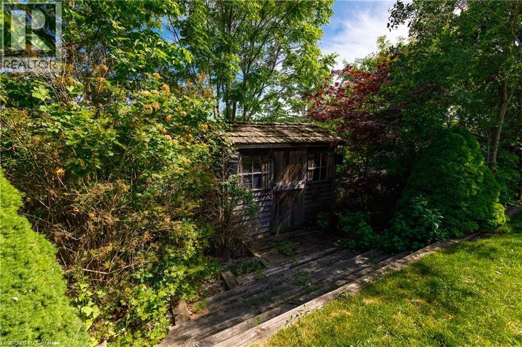 Rustic storage shed featuring wood siding and a shake roof - 907 Doon Village Road, Kitchener, ON - Outdoor