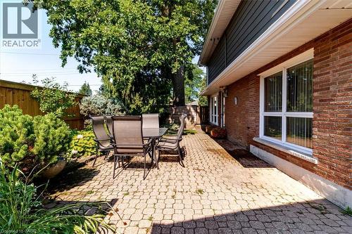 Paver patio featuring brick exterior, white window trim, and established landscaping - 69 Pleasant Avenue, Hamilton, ON - Outdoor
