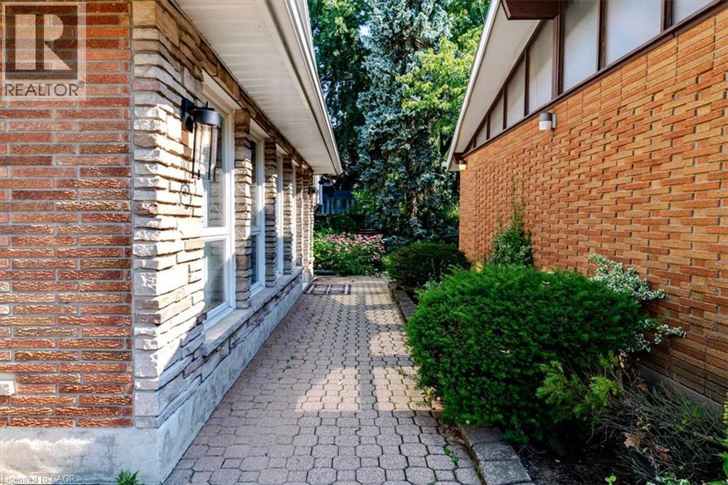 Paver stone pathway situated between house and detached garage - 69 Pleasant Avenue, Hamilton, ON - Outdoor With Exterior