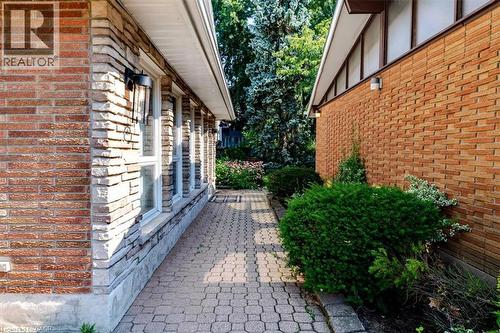 Paver stone pathway situated between house and detached garage - 69 Pleasant Avenue, Hamilton, ON - Outdoor With Exterior