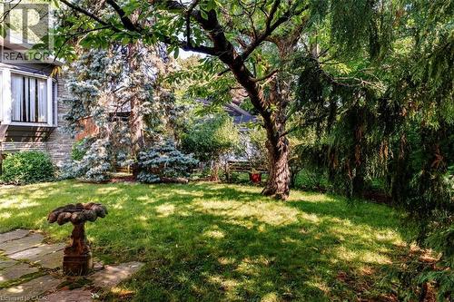 Landscaped rear yard featuring mature trees and a manicured lawn - 69 Pleasant Avenue, Hamilton, ON - Outdoor