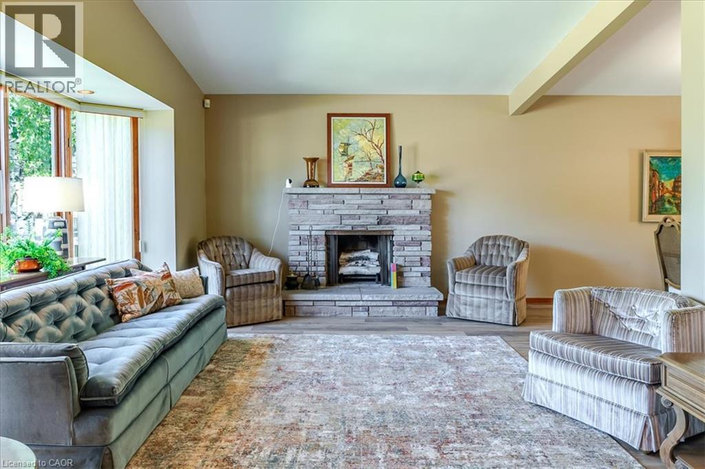 Living space featuring a stone-clad fireplace and hearth - 69 Pleasant Avenue, Hamilton, ON - Indoor Photo Showing Living Room With Fireplace