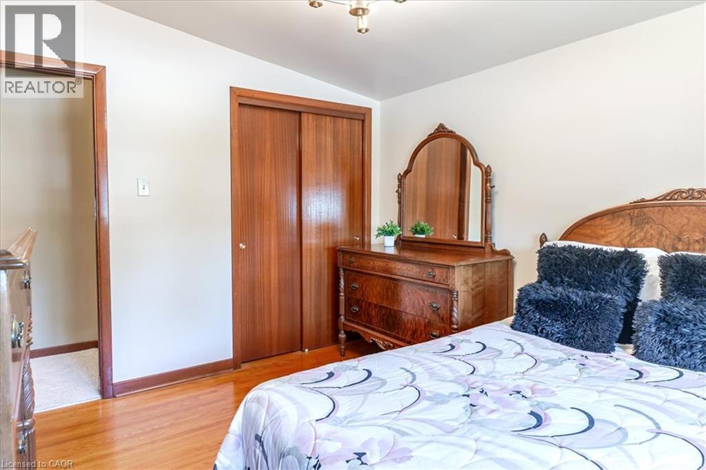 Bedroom featuring wood-finish flooring, light-colored walls, and a ceiling-mounted light fixture - 69 Pleasant Avenue, Hamilton, ON - Indoor Photo Showing Bedroom