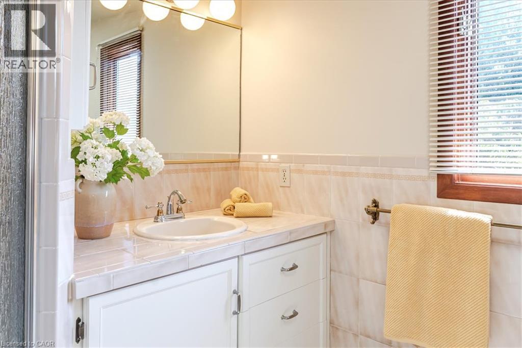 Elegant bathroom vanity featuring a round porcelain sink, marble-finish countertop, and ample storage with white cabinetry - 69 Pleasant Avenue, Hamilton, ON - Indoor Photo Showing Bathroom