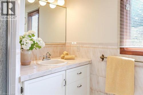 Elegant bathroom vanity featuring a round porcelain sink, marble-finish countertop, and ample storage with white cabinetry - 69 Pleasant Avenue, Hamilton, ON - Indoor Photo Showing Bathroom