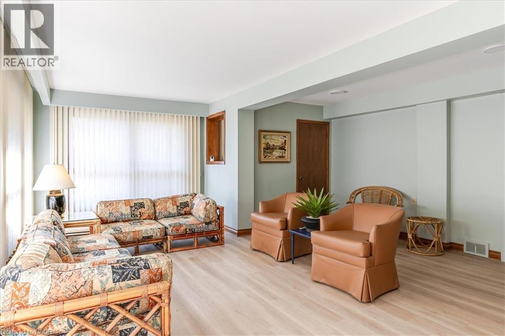 Lower level bright sun room featuring light wood-finish flooring - 69 Pleasant Avenue, Hamilton, ON - Indoor Photo Showing Living Room