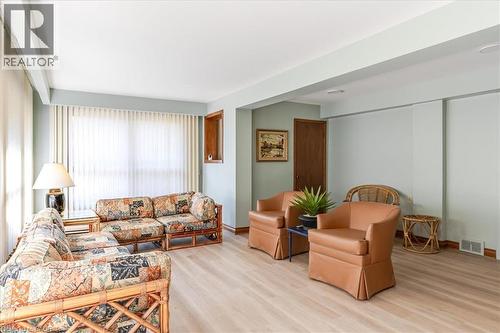 Lower level bright sun room featuring light wood-finish flooring - 69 Pleasant Avenue, Hamilton, ON - Indoor Photo Showing Living Room