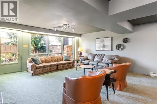 Lower level Recreation Room featuring expansive window wall, light-colored carpeting, recessed lighting, and wall-mounted light fixtures - 69 Pleasant Avenue, Hamilton, ON - Indoor Photo Showing Living Room