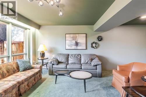 Living area featuring a green ceiling, light-colored walls, and carpeting - 69 Pleasant Avenue, Hamilton, ON - Indoor Photo Showing Living Room