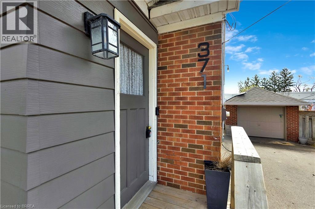 Exterior featuring horizontal siding, brick accents, and an entry door with a multi-pane glass insert - 371 Ottawa Street S, Kitchener, ON - Indoor Photo Showing Other Room