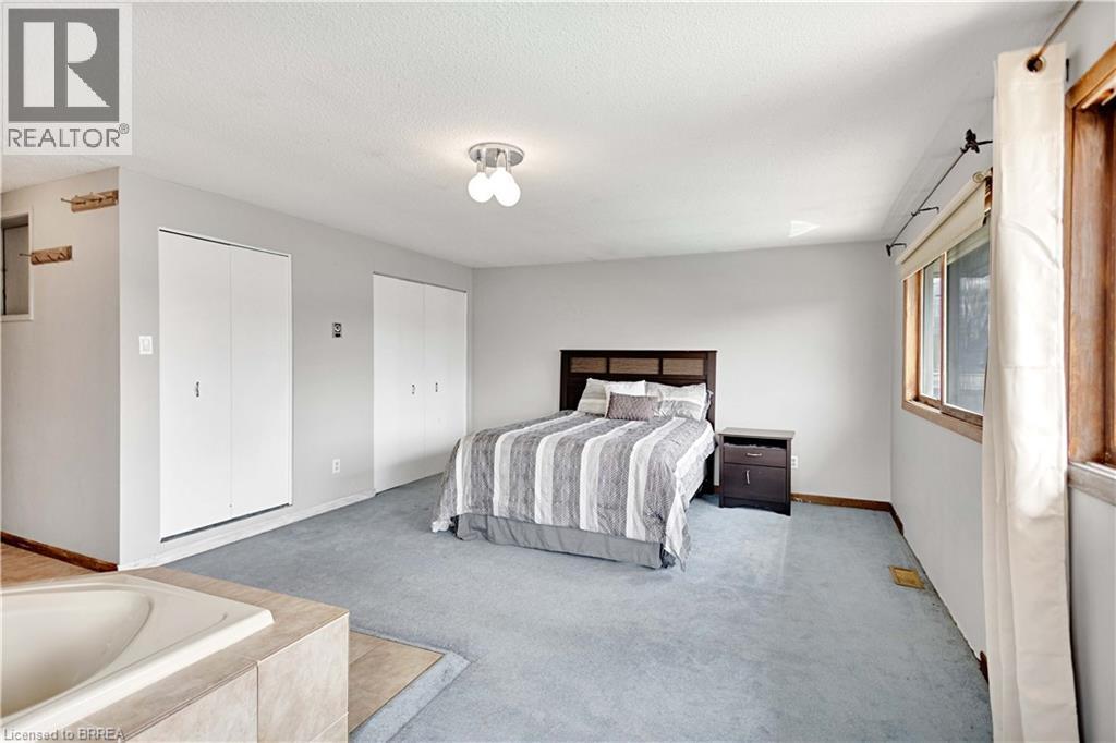 Spacious room featuring light blue carpet, white walls, and a built-in jetted tub with tile surround - 371 Ottawa Street S, Kitchener, ON - Indoor Photo Showing Bathroom